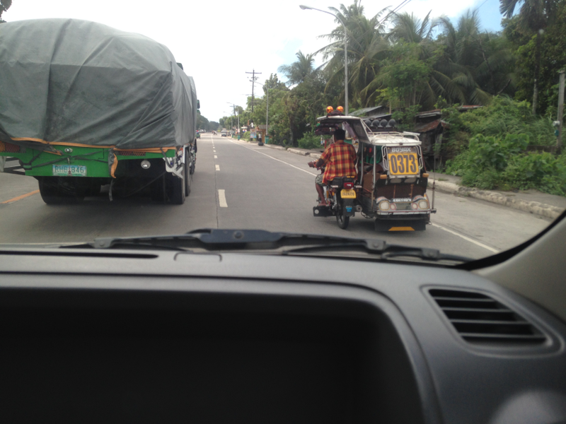 Comparing the size of a sugarcane truck and a tricycle